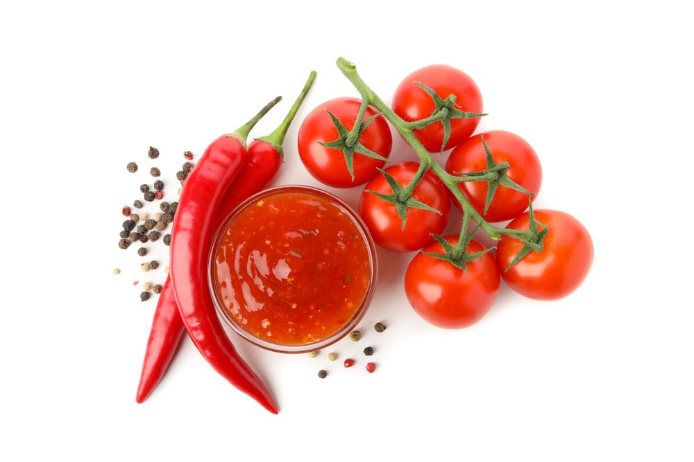 Branch of tomatoes, pepper and sauce isolated on plain background