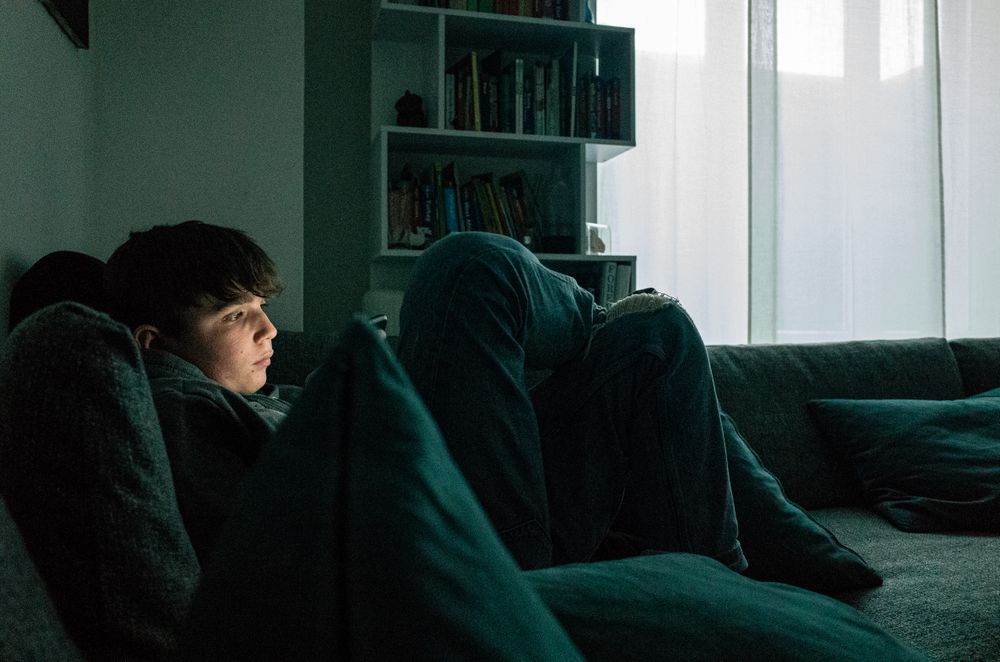 Boy using phone and sitting on couch