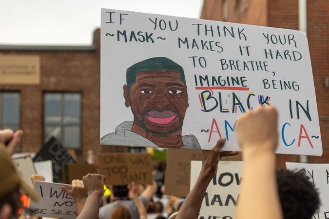 Man raising poster of George Floyd amid protest