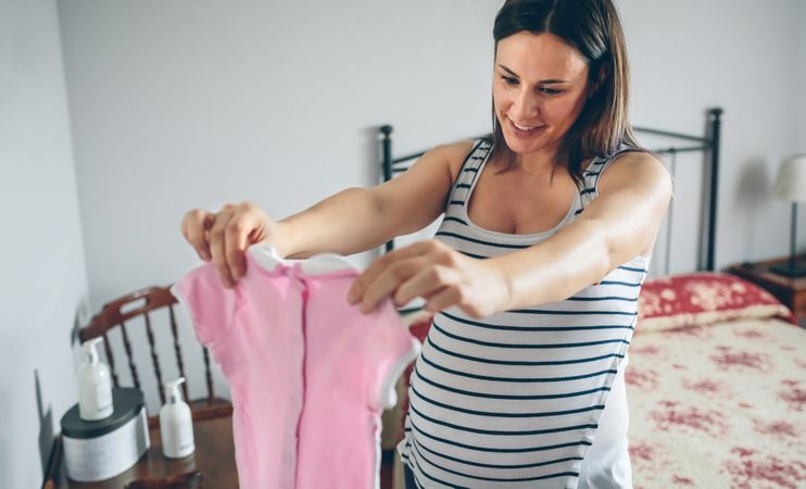 Pregnant looking at baby girl dress