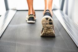 Ankles of male on running machine