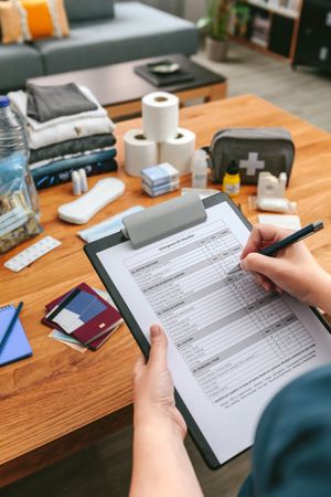 Woman doing checklist of emergency backpack