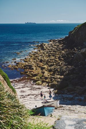 People in a rocky cove in Cornwall