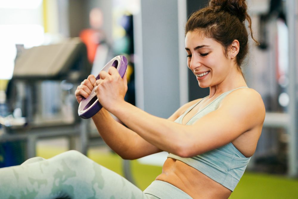 Woman doing ab twists in gym on mat