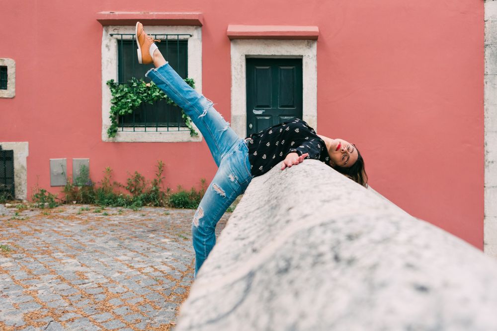 Casual woman dancing on old city street