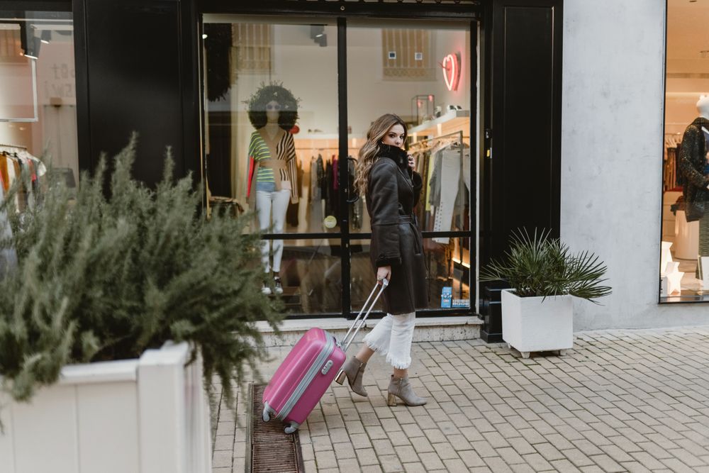 Woman with suitcase walking on street