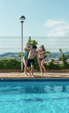 Friends playing with water pistols in the pool
