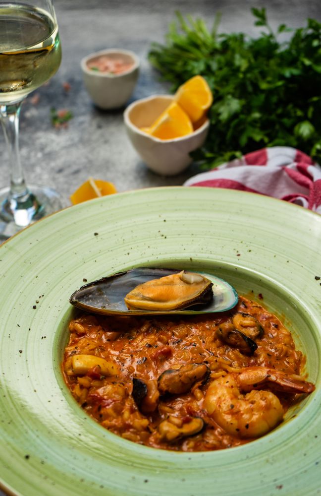 Risotto with sea food served with chill wine and lemon, vertical