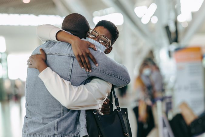 Black couple hugging at airport