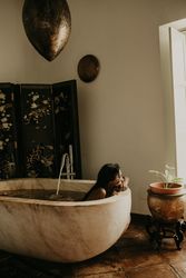 Melancholic Woman sitting and washing in bath