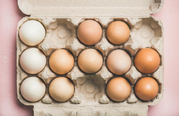 Light, tan, and brown eggs in egg carton