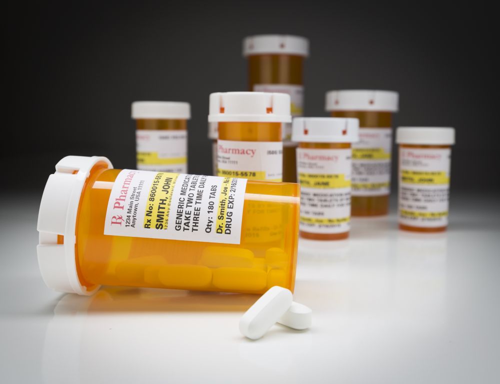 Medicine Bottles and Pills on Reflective Surface With Grey Background