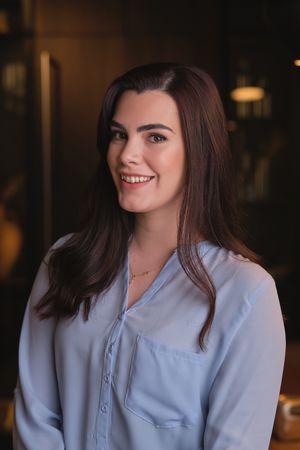 Smiling young woman in blouse looking at camera