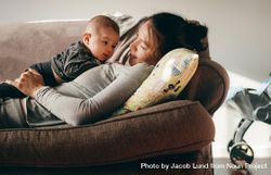 Close up of a young mother lying on couch with her baby 4AgGz0