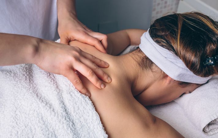 Client receiving shoulder massage in spa