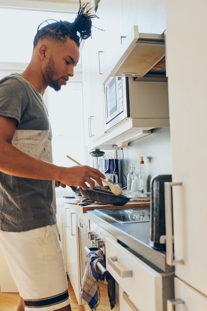 Young Black male cooking dinner