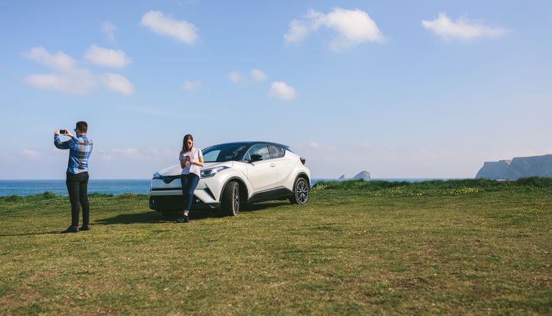Couple traveling by car photographing the landscape