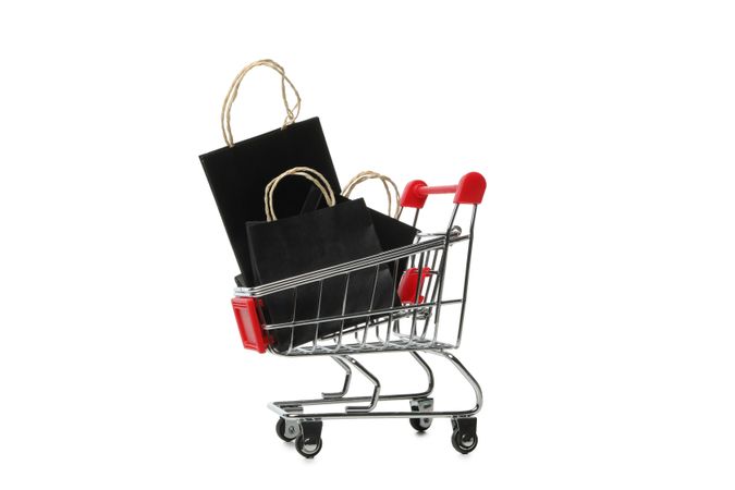 Shop cart with paper bags isolated on bright background