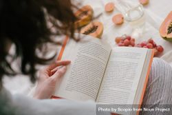 Back view of woman reading a book near fruits 4mw8z0