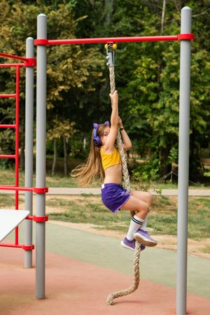 Girl climbing on sports ground