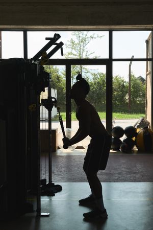 Black guy using exercise machine in gym