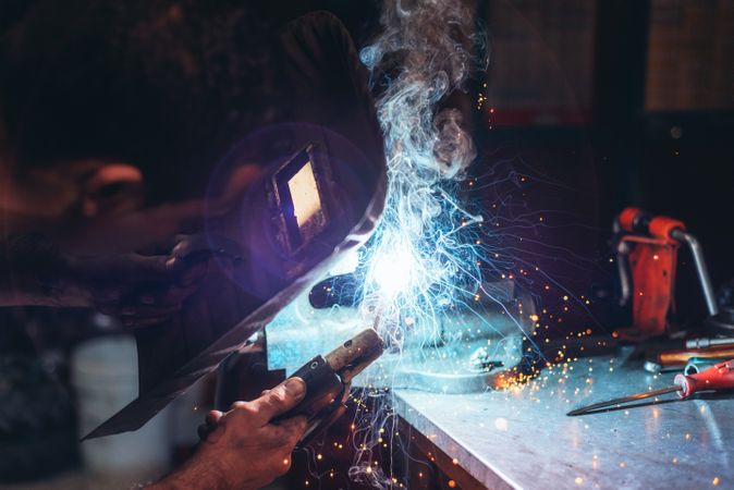 Professional welder in mask welding metal