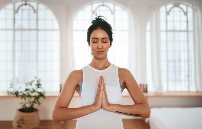 Peaceful woman in yoga position with hands joined together