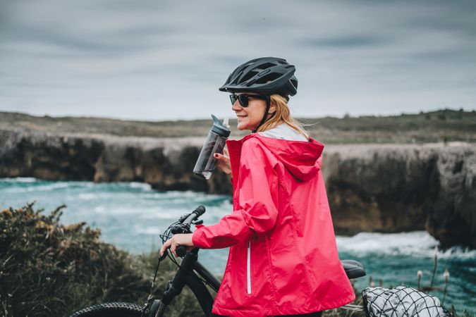 Female bicyclist holding sport bottle
