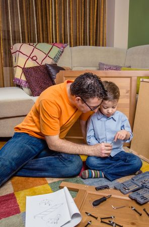 Father and son assembling a new furniture for home