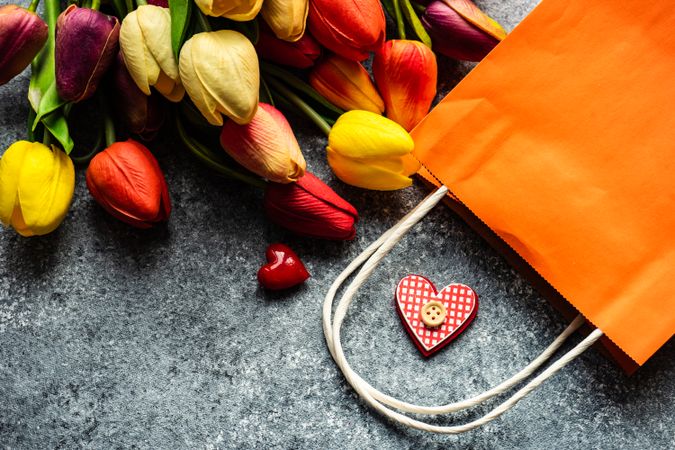 Top view of counter with tulips, hearts and shopping bag
