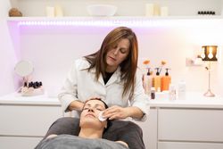 Female client in spa receiving facial