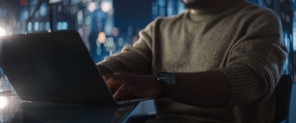 Close Up Of Successful Black Businessman Working on Laptop in Big City Office Late at Night.
