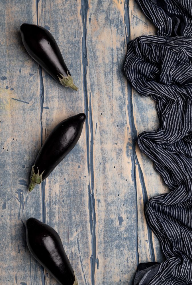 Ripe eggplants on shabby tabletop