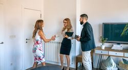 Businesspeople greeting and receiving businesswoman