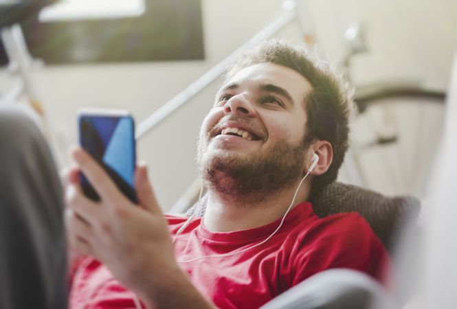 Happy man listening to music on couch