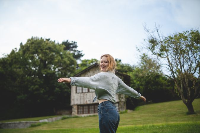 Content female dancing on grass in countryside