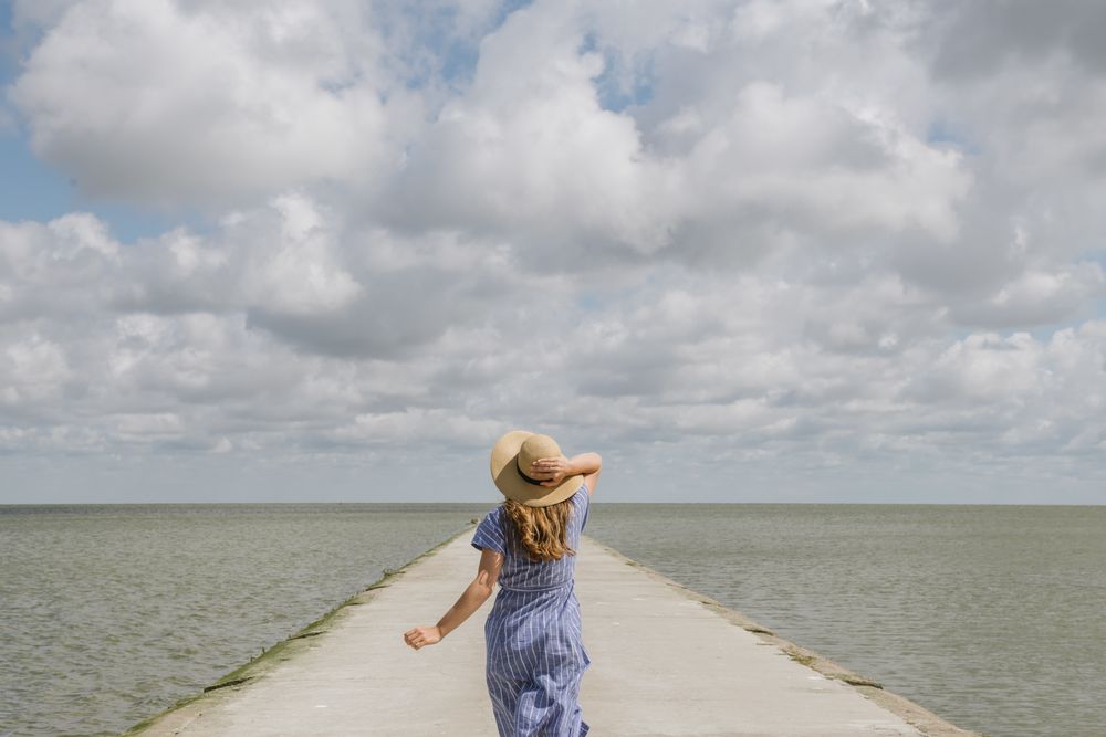 Young woman running on sea wharf