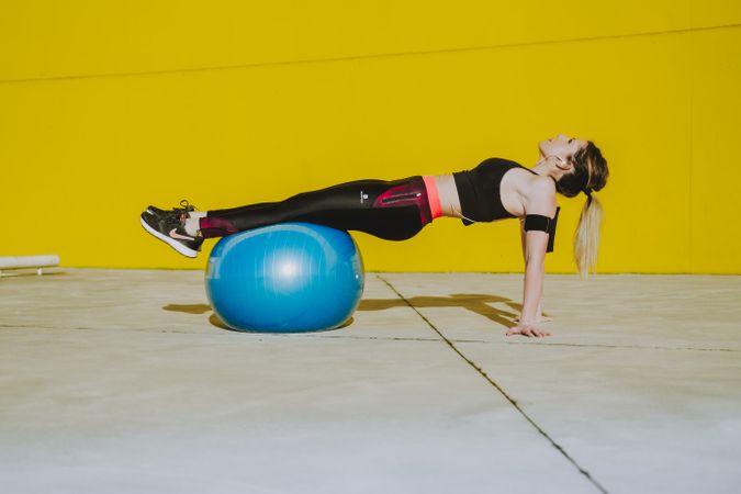 Woman doing plank with legs on ball