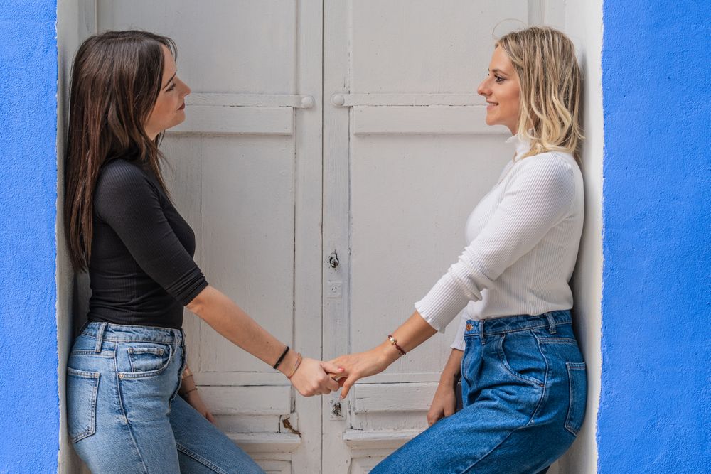 Positive women holding hands in doorway