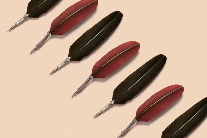 Red quill pens on neutral background