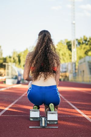 female athlete prepared to run on an athletics track
