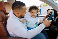 Parent playing with son in car