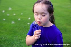 Young child blowing dandelion in a park 5z9vk0