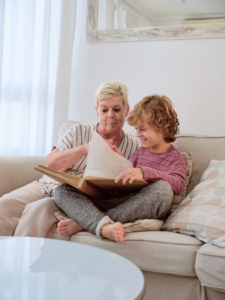Aged granny and smiling boy having to flip pages of album