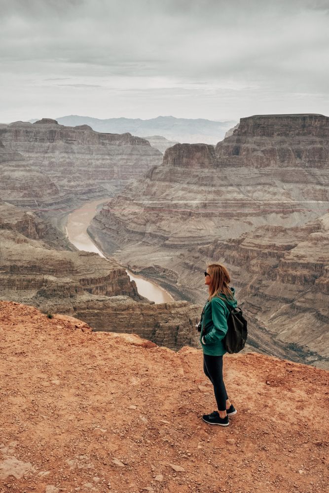 Female relaxing on cliff and admiring picturesque view