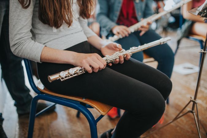 Cropped shot of female student holding flute instrument