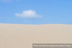 Lonely cloud over a dessert dune against blue sky 5Q287e