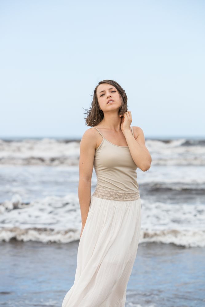 Charming young woman on shore near water