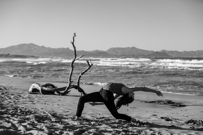 Young woman dancing and posing near water on shore