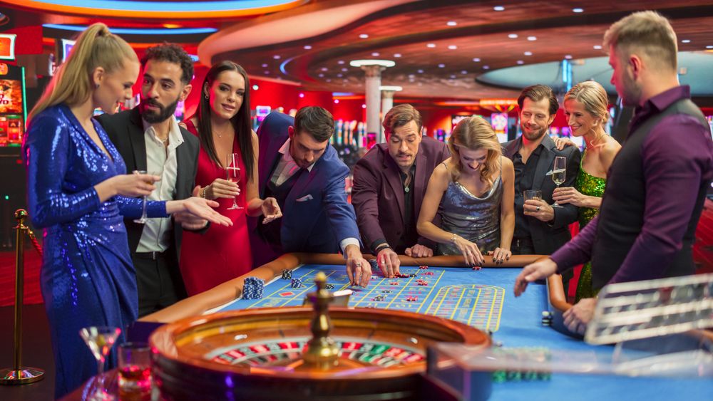 Gathering of Wealthy Young Individuals, Standing Together Around a Roulette Table in a Contemporary Casino Setting.